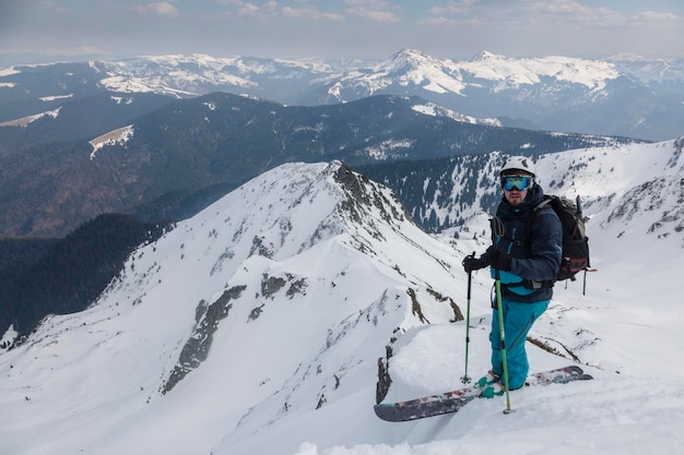 An active skier with a backpack in the middle of the mountain range