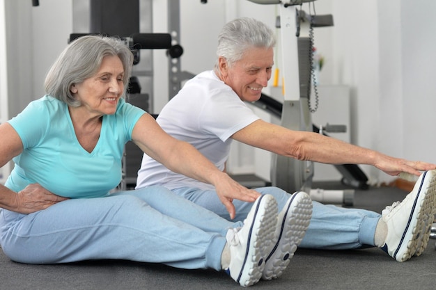 Active smiling senior couple exercising in gym