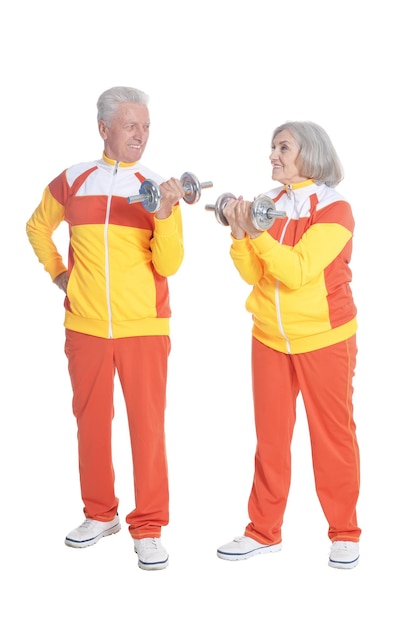 Active smiling senior couple exercising isolated on white background