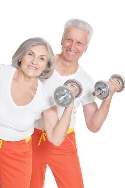 Active smiling senior couple exercising isolated on white