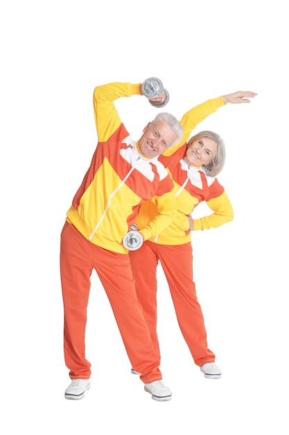 Active smiling senior couple exercising isolated on white