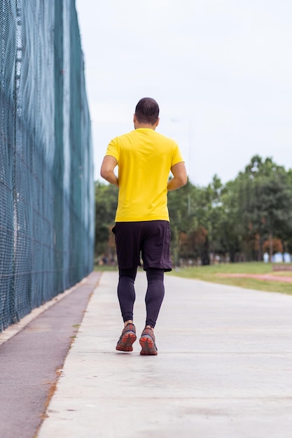 Active sportsman in tracksuit enjoys a healthy lifestyle running on an empty urban track