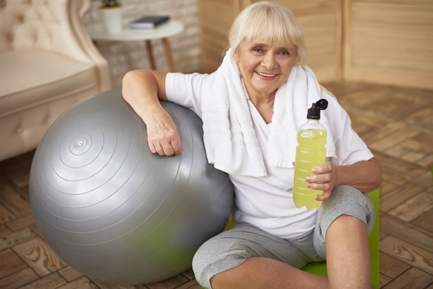 Photo active sporty old lady drinks antioxidants water.