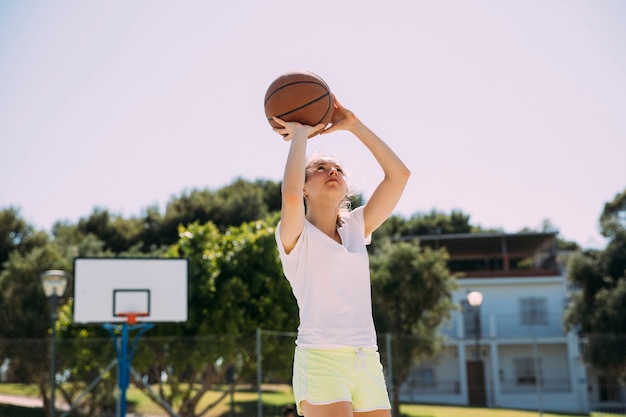 Adolescente attivo giocando a basket a corte