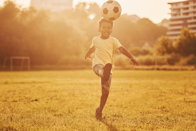 Active weekend time spending African american kid have fun in the field at summer daytime