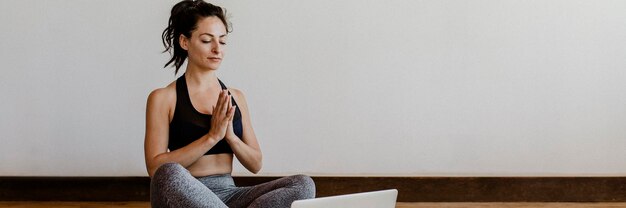Фото Активная женщина изучает йогу онлайн через ноутбук
