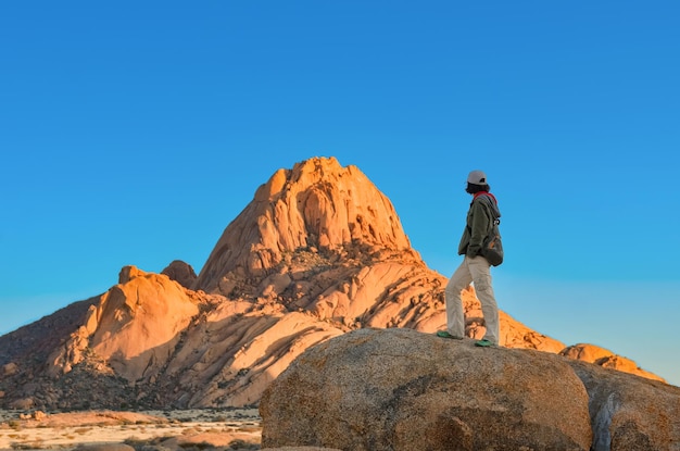 Active woman tourist travels in Spitzkoppe nature reserve girl traveler hiking Namibia