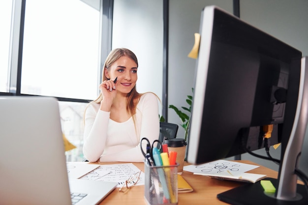 Active working Young adult woman in formal clothes is indoors in the office