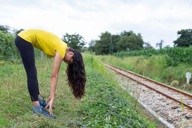 Active young woman doing stretching exercise in countryside