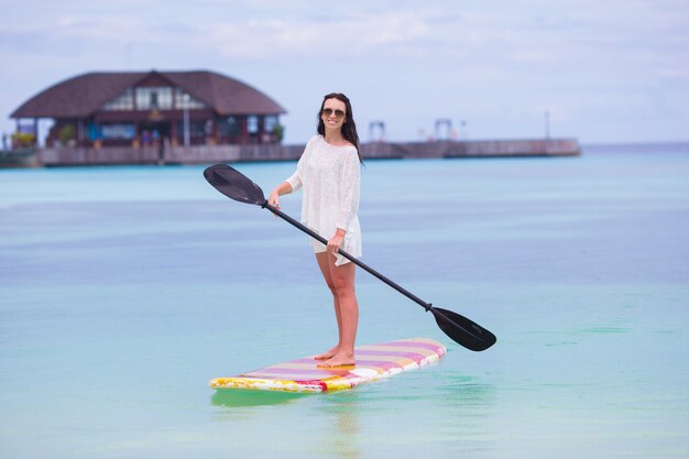 Active young woman on stand up paddle board