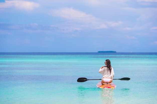 Active young woman on stand up paddle board