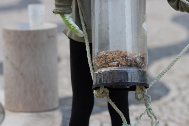 Activist wears a container on their back to store cigarette bulls abandoned on the street