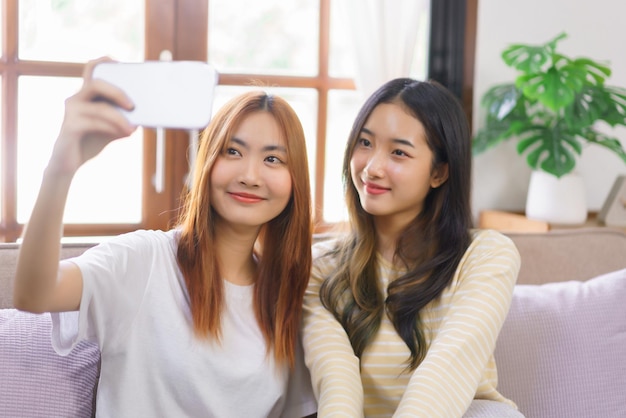 Activiteit thuis concept Lgbt lesbisch koppel glimlacht en gebruikt smartphone om samen een selfie te maken