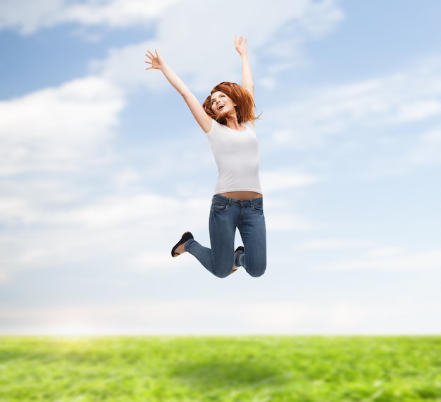 activity and happiness concept - smiling teenage girl in white blank t-shirt jumping