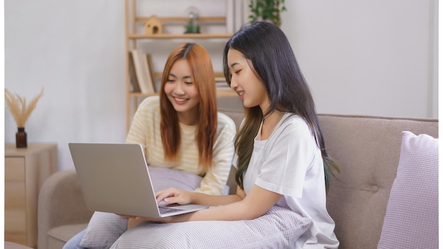 Activity at home concept lgbt lesbian couple read and typing
data on laptop while working together