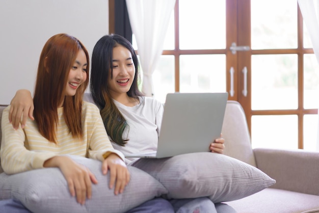 Activity at home concept LGBT lesbian female embraces her girlfriend while watching movie together