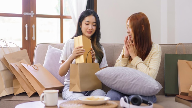 Activity at home concept LGBT lesbian female shocked face while receiving gift box from girlfriend