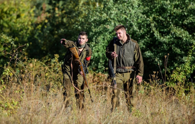 Activity for real men concept Hunters gamekeepers looking for animal or bird Hunting with friends Hunters friends enjoy leisure Hunters with rifles in nature environment Teamwork and support