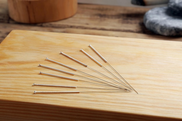 Acupuncture needles on wooden board