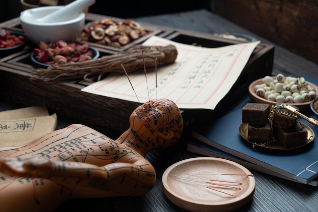 Acupunctuurmodellen en medische boeken liggen op tafel