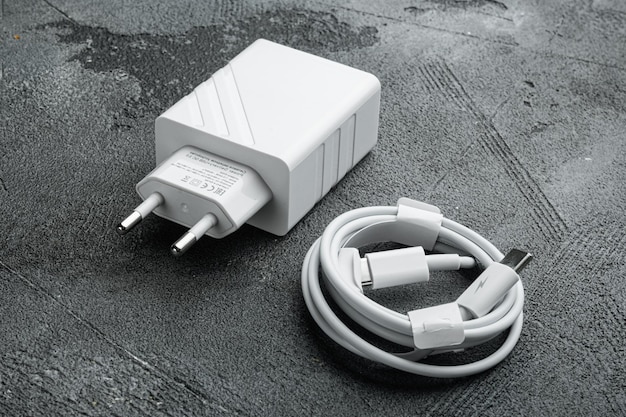 Adapter and USB Cable new package set, on gray stone table background