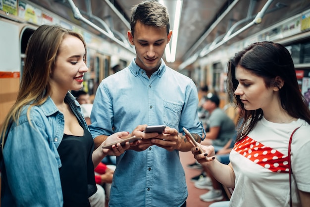 Giovani tossicodipendenti che usano i telefoni in metropolitana, problemi di dipendenza, persone con dipendenza sociale, stile di vita sotterraneo moderno