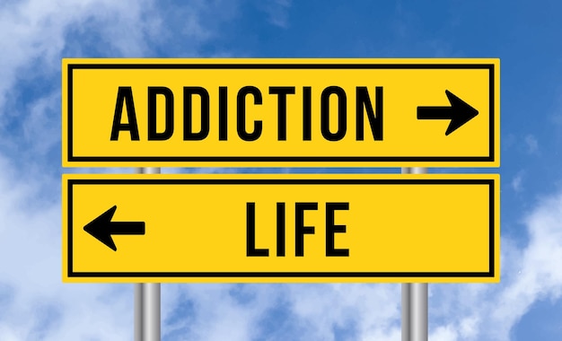 Addiction or life road sign on sky background