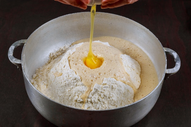 Adding egg to yeast dough for making bread