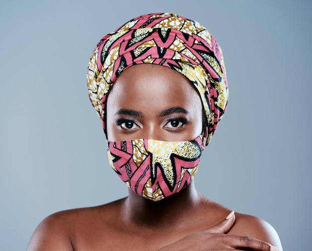 Adding a little beauty to lockdown Studio portrait of a beautiful young woman wearing a mask against a grey background