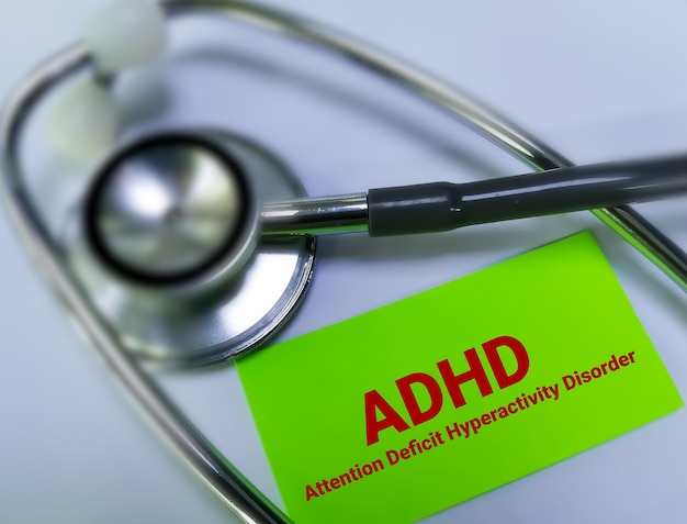 ADHD or Attention deficit hyperactivity disorder medical term on card with stethoscope.