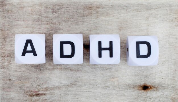 Adhd in letter dobbelstenen op een rustiek en natuurlijk hout met kopieerruimte