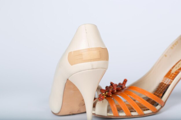 Photo adhesive bandage attached to summer high heels. closeup