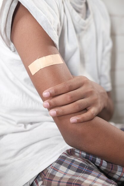 Adhesive bandage on young mans arm