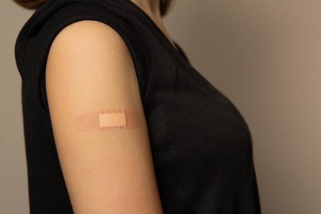 Adhesive plaster on an woman arm after taking vaccine