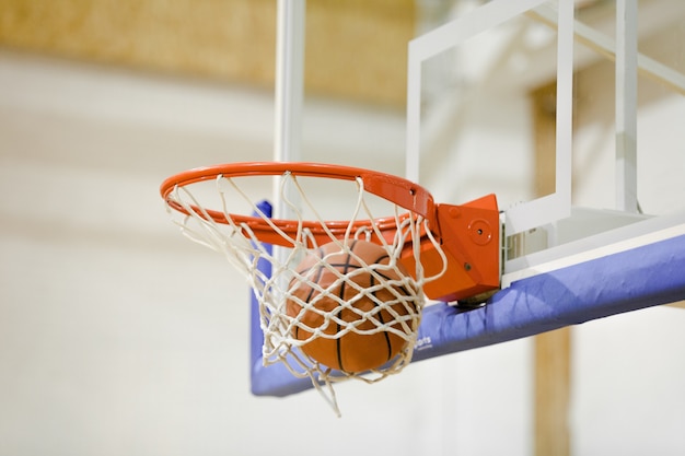 Adidas Basketball ball hitting basket in gym