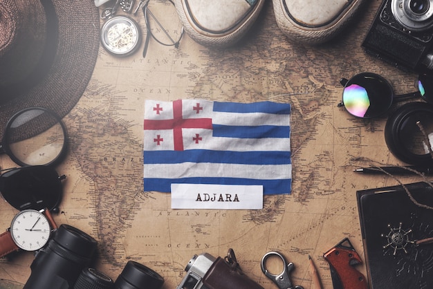 Adjara Flag Between Traveler's Accessories on Old Vintage Map. Overhead Shot