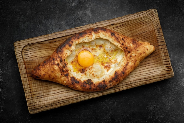 Adjarische khachapuri met ei op een houten plank