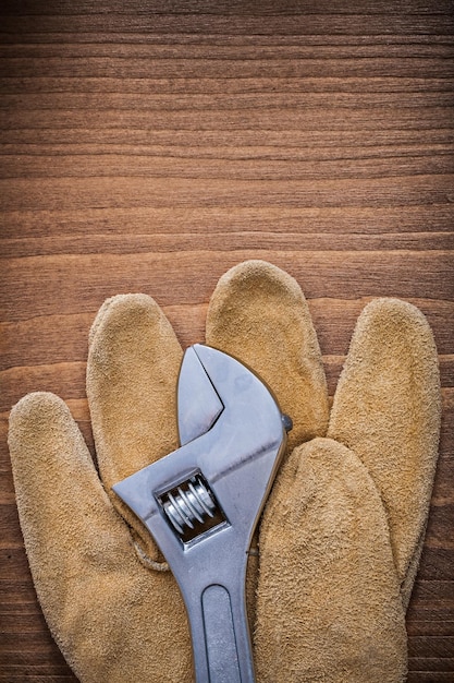 Adjustable key leather protective gloves on wood board construction concept