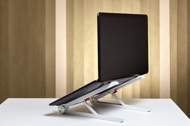 Photo adjustable portable aluminum laptop  holder folding with open pc notebook.