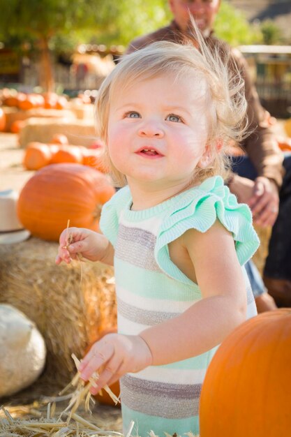 Adorabele baby meisje die plezier heeft in de Pumpkin PatchxA