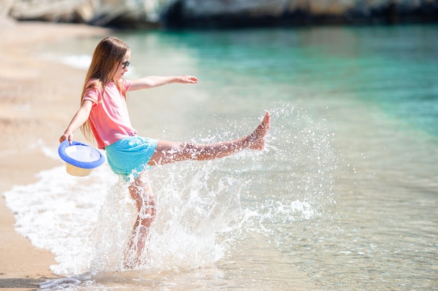 Adorable active little girl at beach during summer vacation