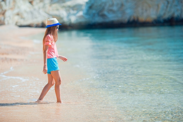 Adorable active little girl at beach during summer vacation