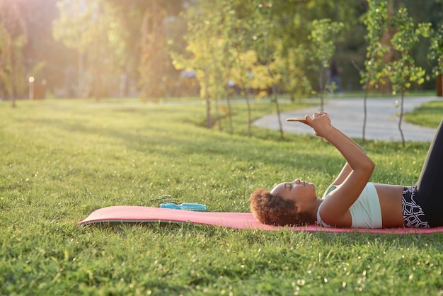 Adorable afro american girl using smartphone in park