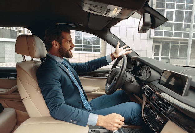 Adorable angry man in formal wear is swearing on the road