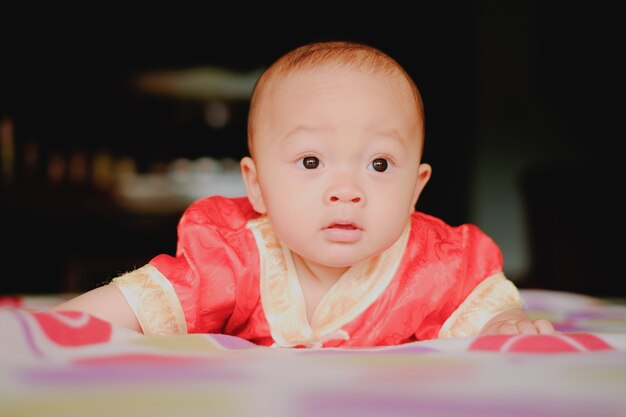 Adorable baby boy in bedroom. Newborn child relaxing in bed. Nursery for young children. 