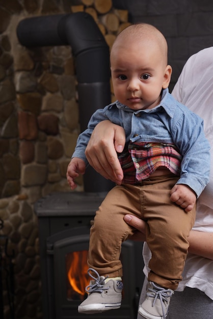 Adorable baby boy in blue denim shirt and brown pants