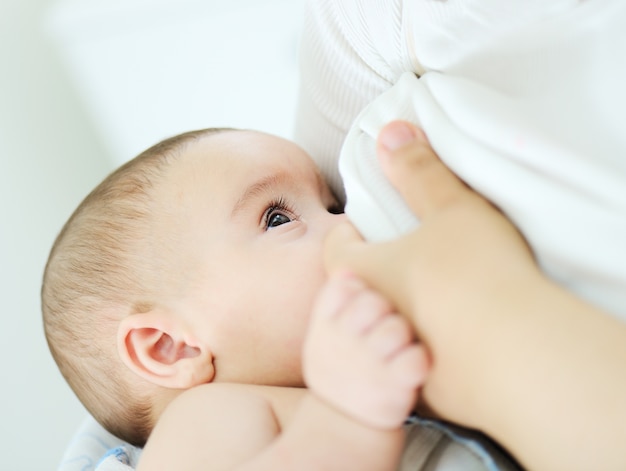 愛らしい赤ちゃんの男の子の母乳を飲む