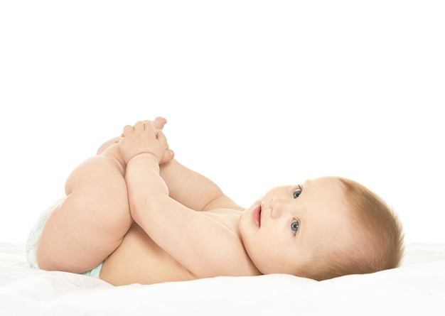 Adorable baby boy lying in pampers on blanket on a white background