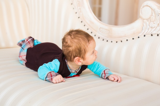 Adorable baby boy lying on tummy in the bedroom