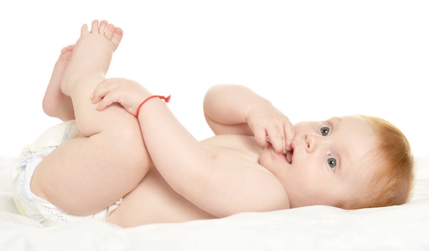 Adorable baby boy in pampers on blanket on a white background